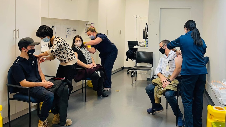 Several patients receive a vaccine at a clinic 