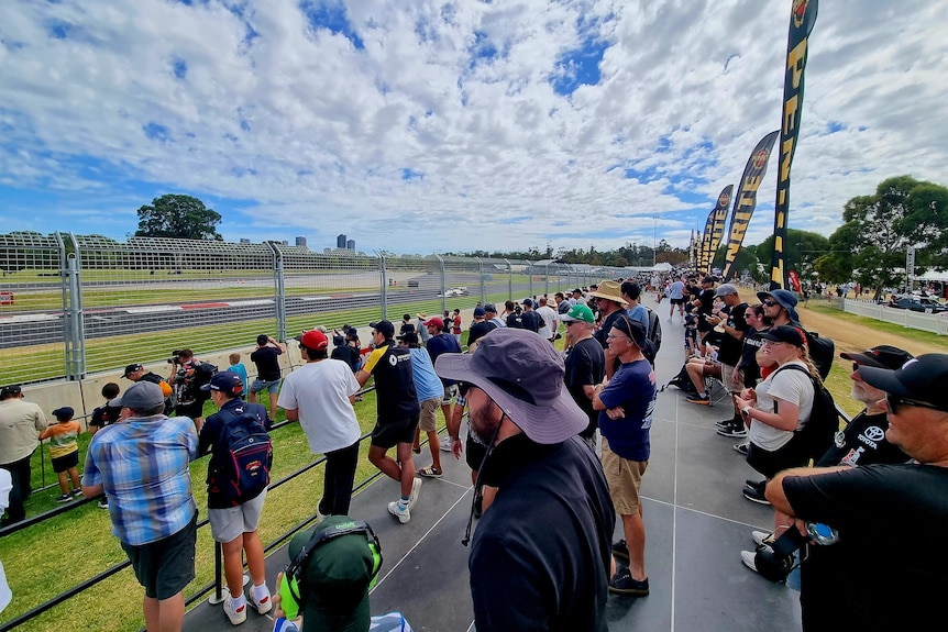 People gather beside a racetrack to watch the Motorsport Festival.