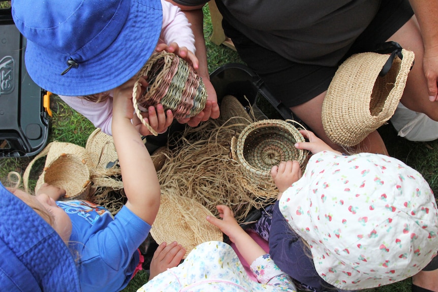 Children touching Aboriginal baskets at a day care in Canberra.