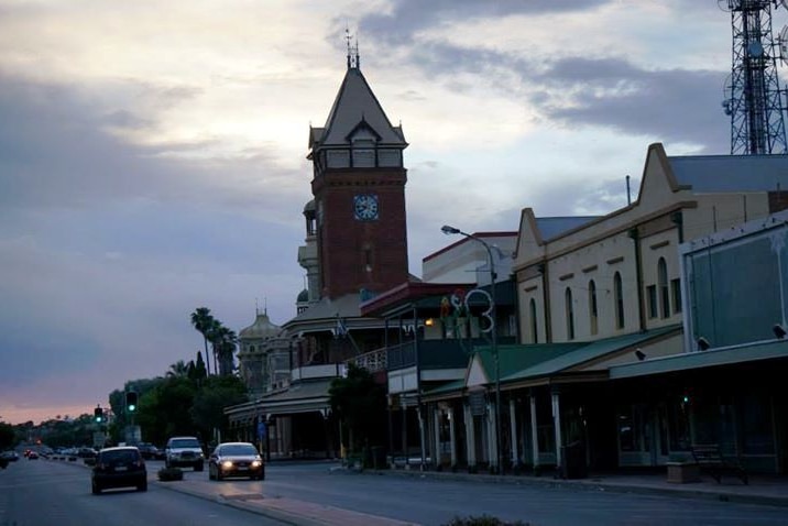 Cars on a street in Broken hill CBD showing town hall tower in background.