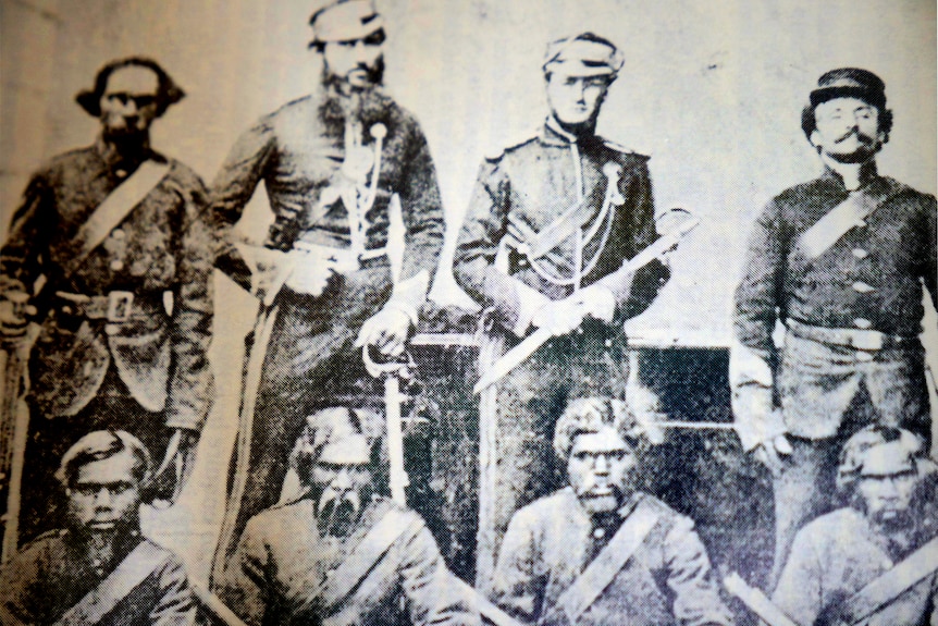 A black and white photo of men in uniform.