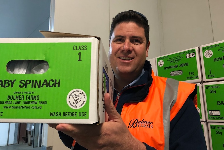 Farmer Andrew Bulmer with a box of spinach from his farm in Gippsland.