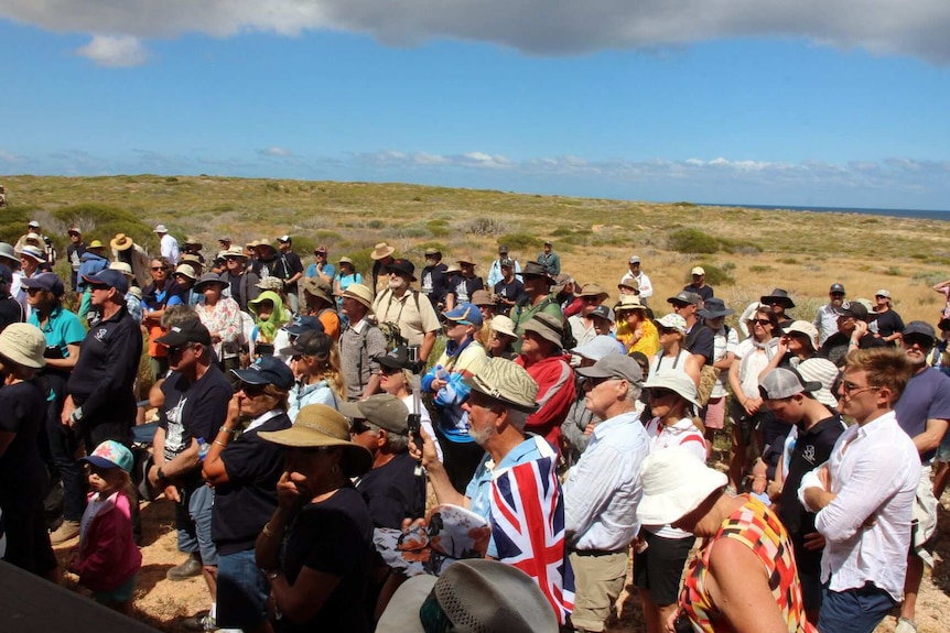 A large crowd of people gathered in sunshine on Dirk Hartog Island.