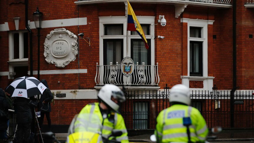 Police motorcyclists briefly stop outside the Ecuadorian embassy in London.