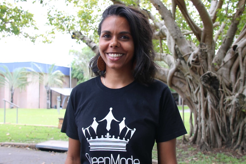 A photo of Elena Wangurra, an Aboriginal dance mentor in the Northern Territory, she is smiling in a black t-shirt.