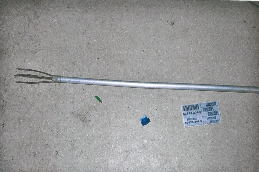 A silver fishing spear laying on the ground