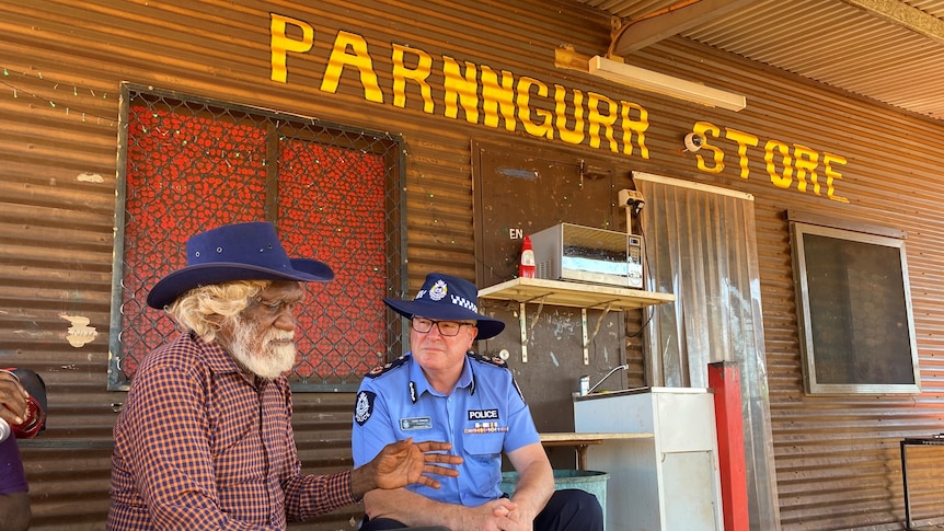 Martu elder Nyari Nyari sitting with Police Commissioner Chris Dawson in from of a general store.