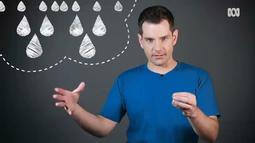 Man stands in front of blackboard showing drawing of raindrops in cloud