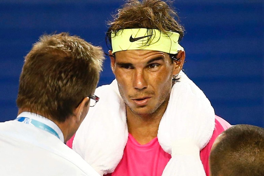 Rafael Nadal speaks to medical staff during his Australian Open match against Tim Smyczek.