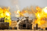 An Israeli artillery unit fires toward targets in Gaza Strip in a burst of flames.