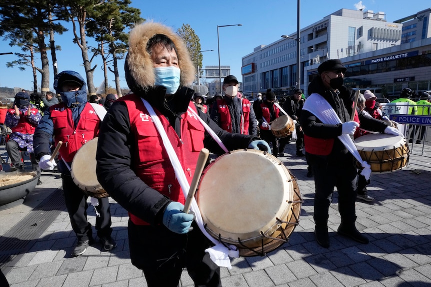 protesters beat drums they carry 