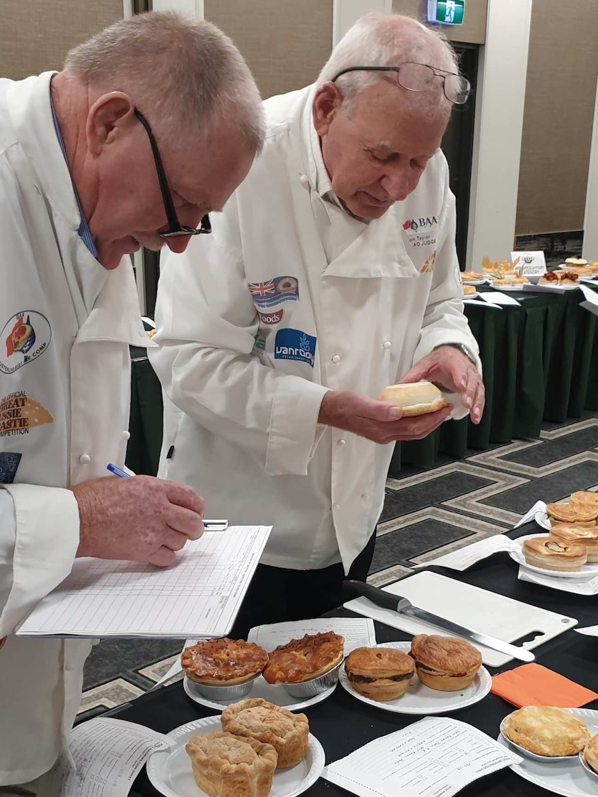 Two men judge the quality of pies in a competition