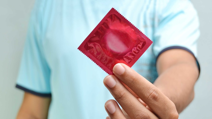 Man holding a condom