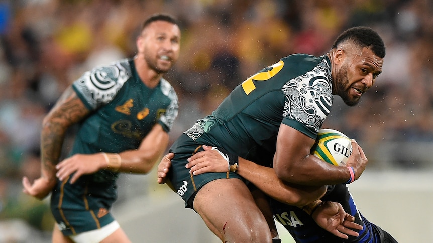 Samu Kerevi is tackled as Quade Cooper watches in the background