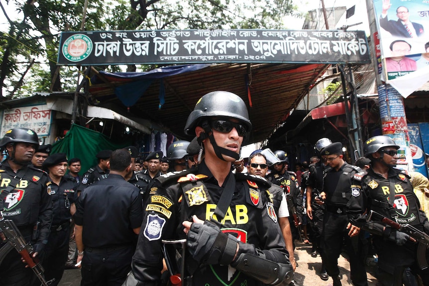 Bangladesh soldiers standing guard outside what looks like a market.