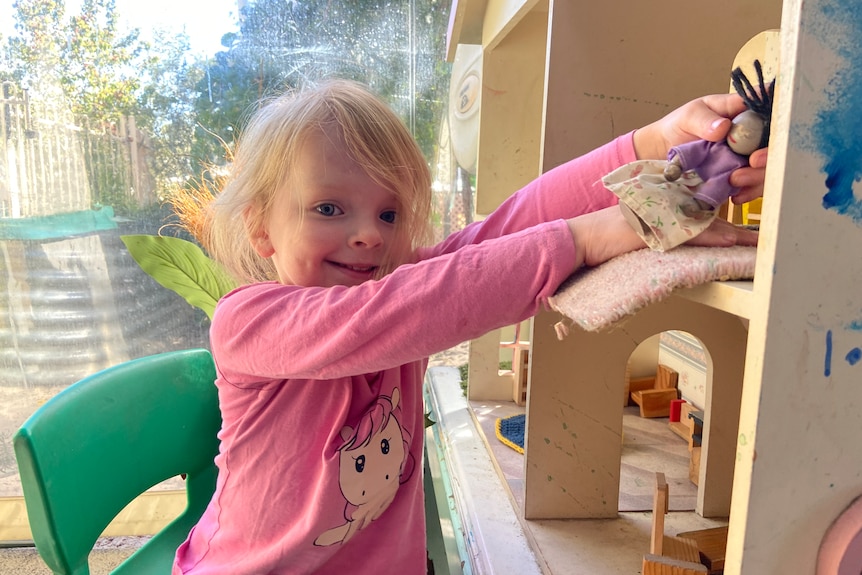 a photo of a girl playing in doll house