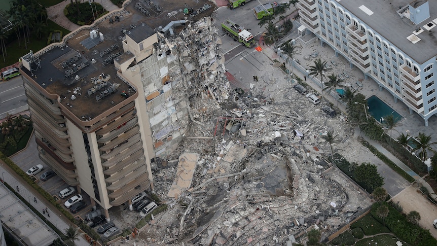 Search and rescue personnel work in the rubble of the 12-story condo tower that crumbled to the ground.