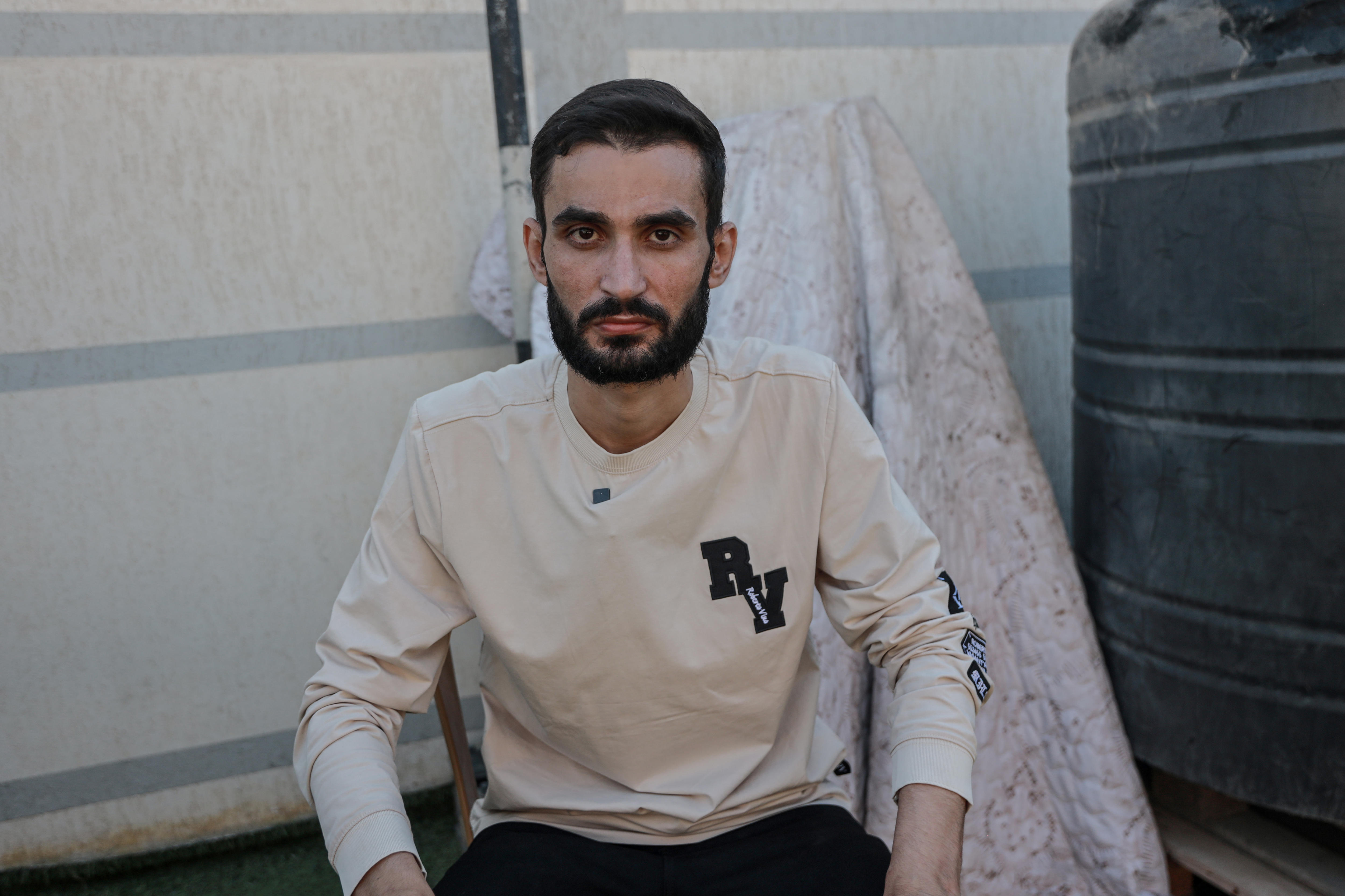 A Palestinian man with a beard sits unsmiling in a chair.