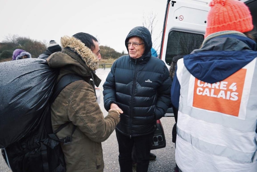 Reverend Bill Crews speaks to a migrant in Dunkirk.