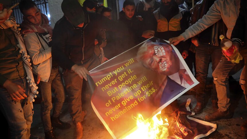 People burn a poster: "Trump! You will never get it. But people of Palestine will never give up their homeland for $$$."