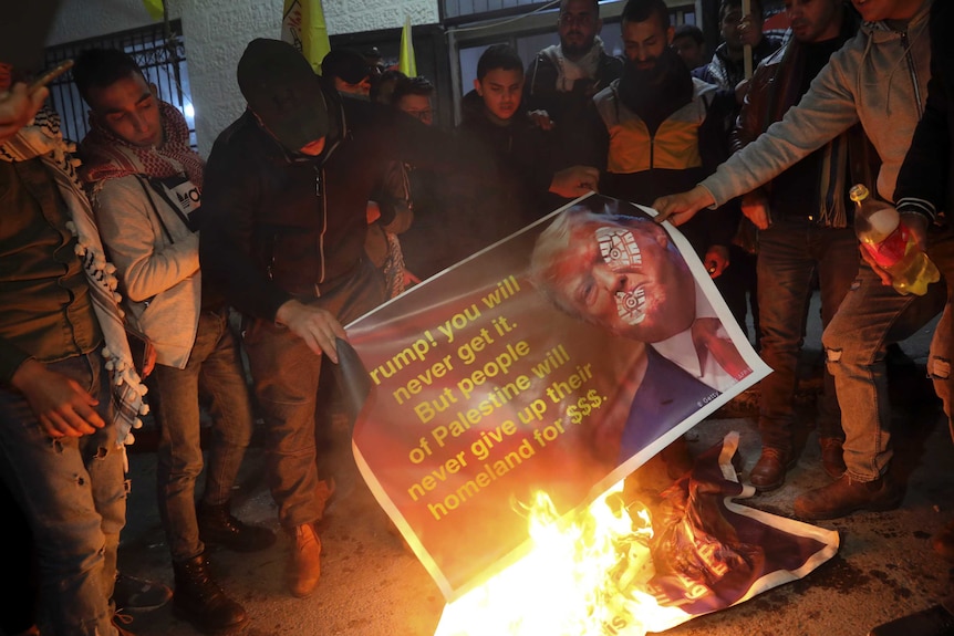 People burn a poster: "Trump! You will never get it. But people of Palestine will never give up their homeland for $$$."