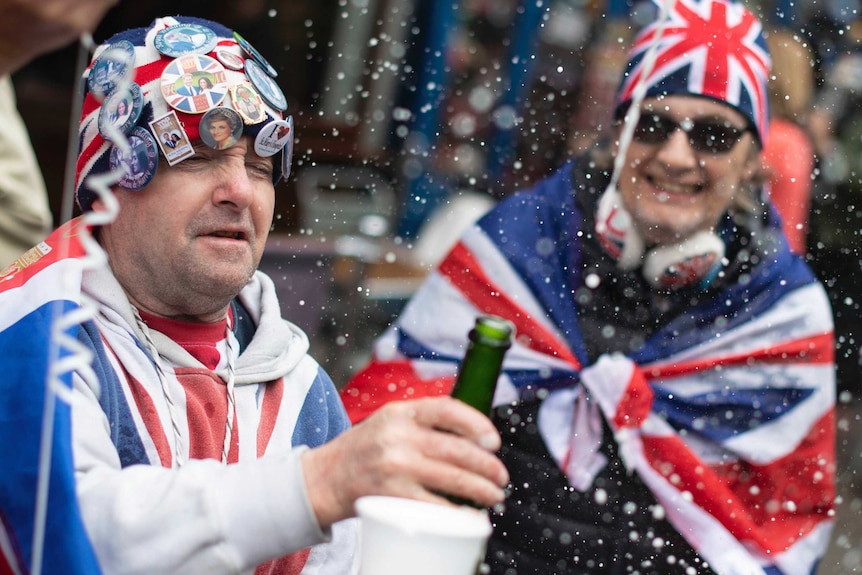 Royal fans celebrate outside Windsor Castle in Berkshire after Buckingham Palace.