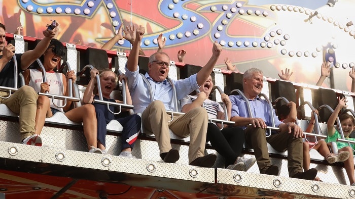 Scott Morrison raises his arms on a ride at the Sydney Royal Easter Show, 2019