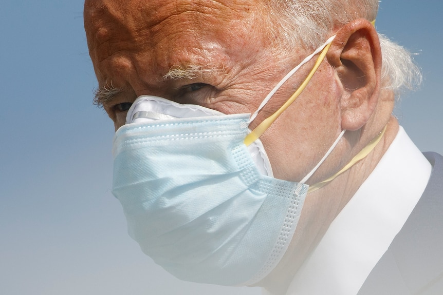 Joe Biden wearing a blue surgical mask over a white respirator-style mask 