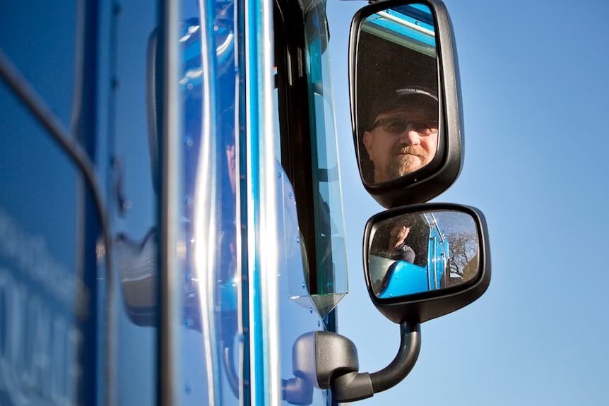 Steven can be seen in the rear view mirror of his B Double truck.