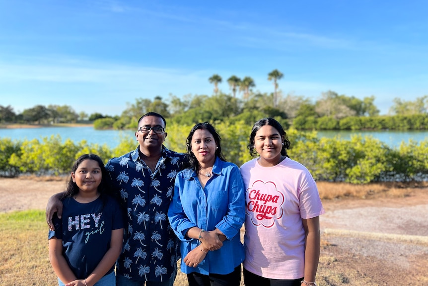 a family standing together in front of a lake