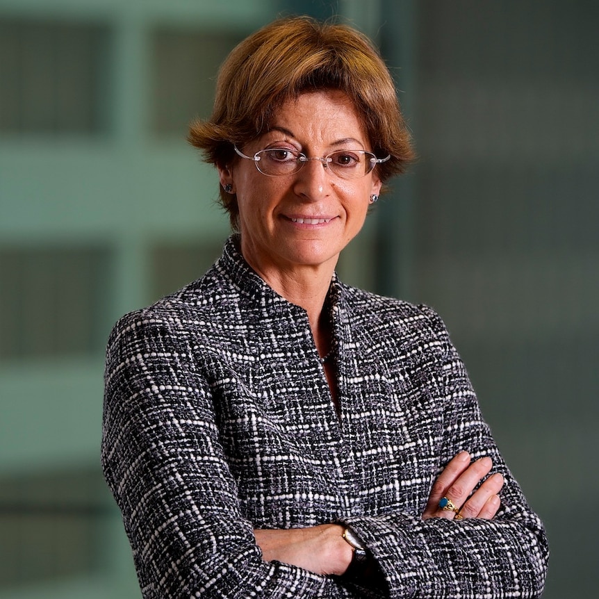 Deborah Glass stand with her arms folded, posing for the camera.