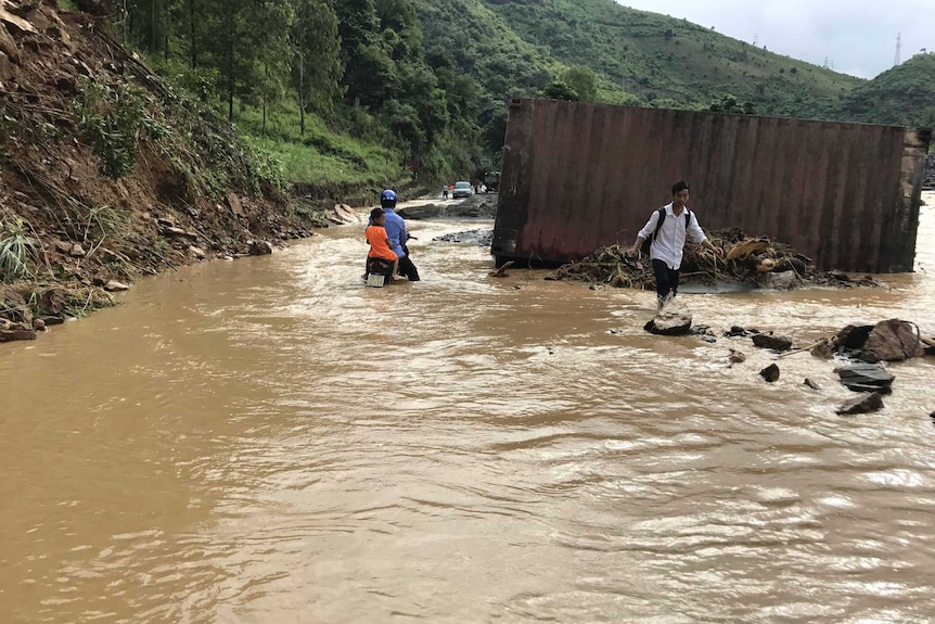 Residents wade through flood water in northern Vietnam