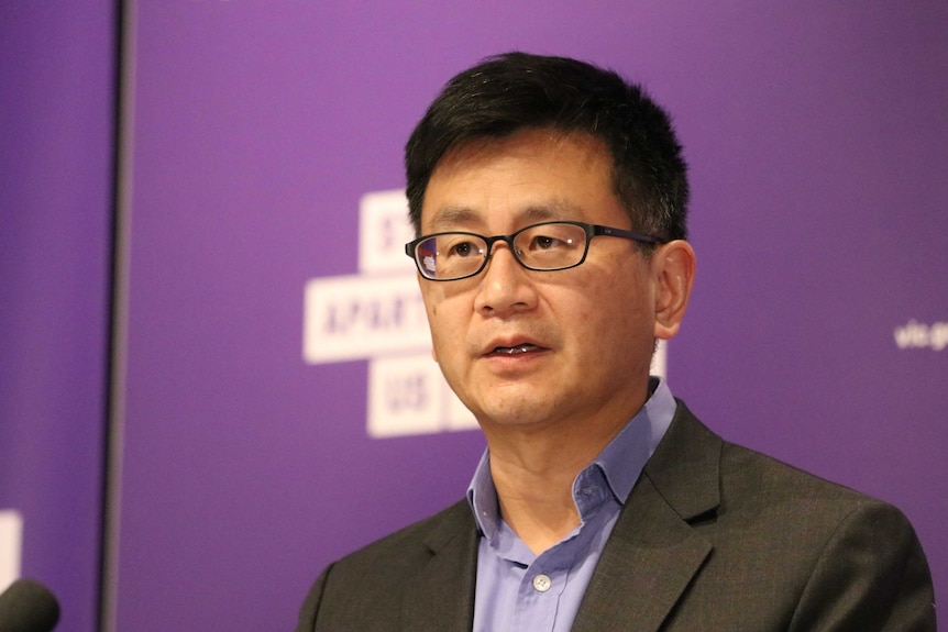 Professor Allen Cheng, who has short dark hair and glasses, stands at a Victorian press conference.