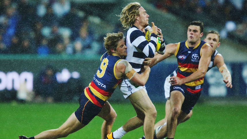 Rory Sloane of the Crows tackles Cameron Guthrie of the Cats