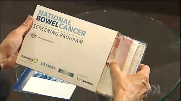 A person opening a bowel cancer screening test kit.