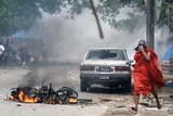 Clashes: A monk runs as tear gas fills the air in downtown Rangoon