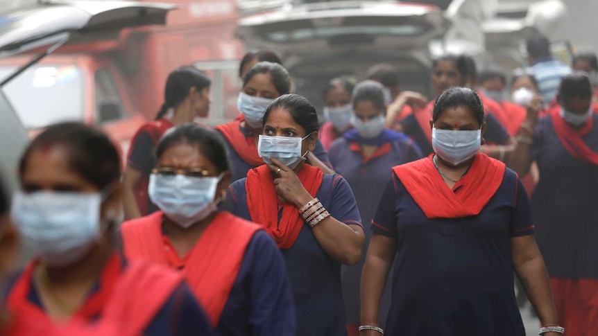 A group of women wearing pollution masks.