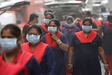 A group of women wearing pollution masks.