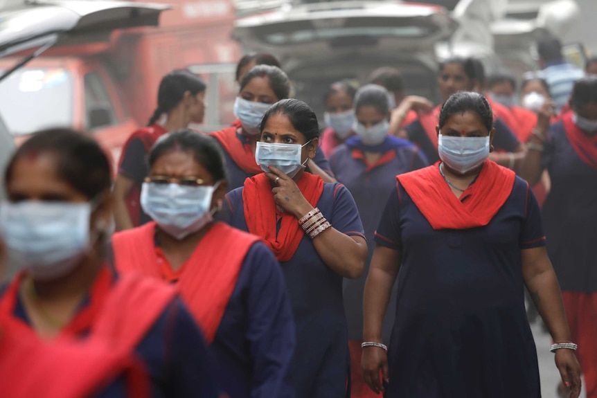 A group of women wearing pollution masks.