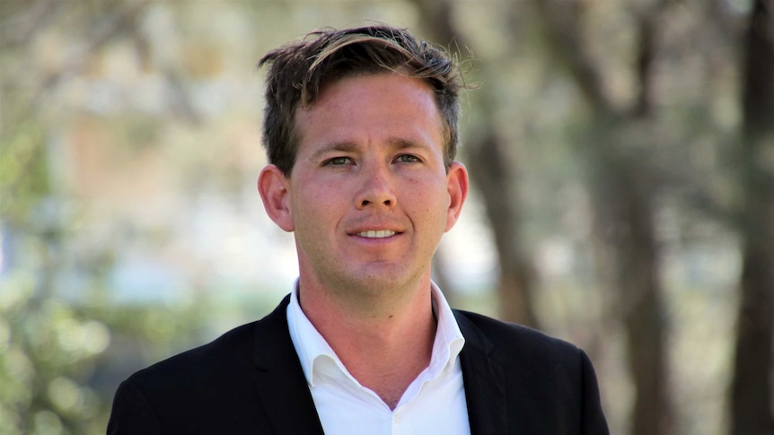 A head and shoulder shot of Mandurah Mayor Rhys Williams with blurred trees in the background.