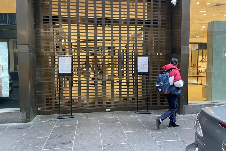 A shop entrance with a security door in place to block people from entering.