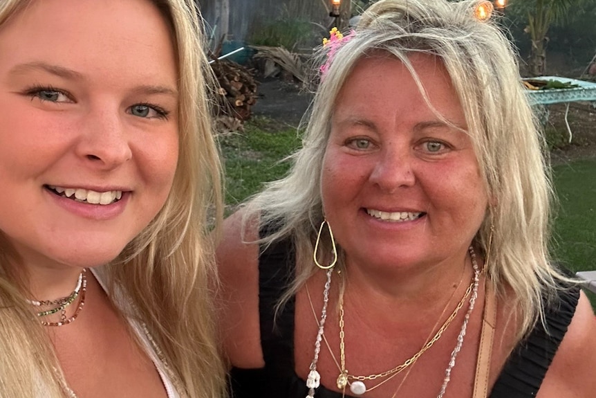 Lisa Evans and her daugther, both blonde and tanned, smiling in a photo.
