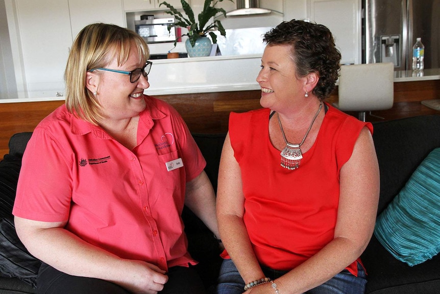 (LtoR) Nurse Sally Haley sits on lounge with cancer patient Belinda Cosgrove.
