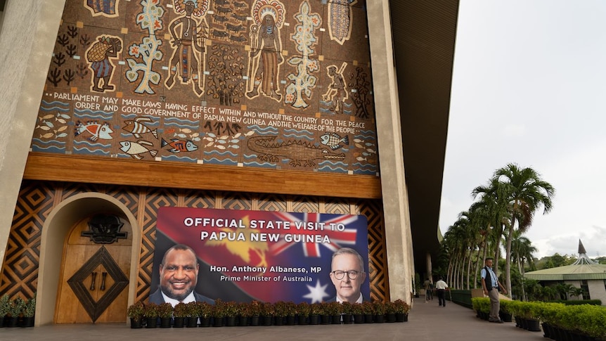 A banner showing Marape and Albanese in front of parliament building in PNG.