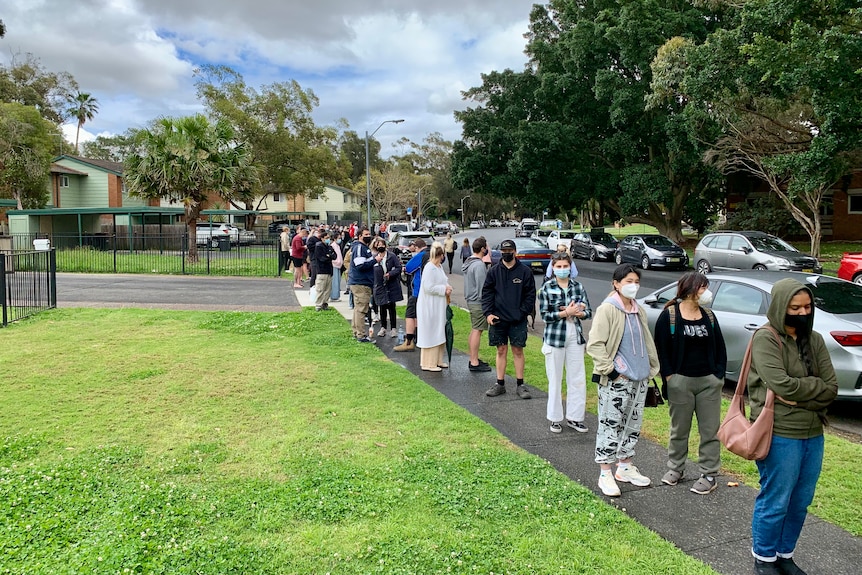 People wearing masks in a queue.