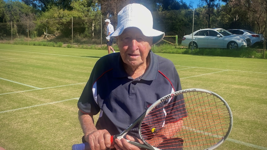 elderly man sitting down holding tennis racquet
