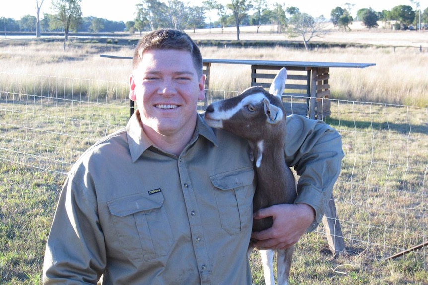 Nathan Jackson cuddles one of his goats on this farm.
