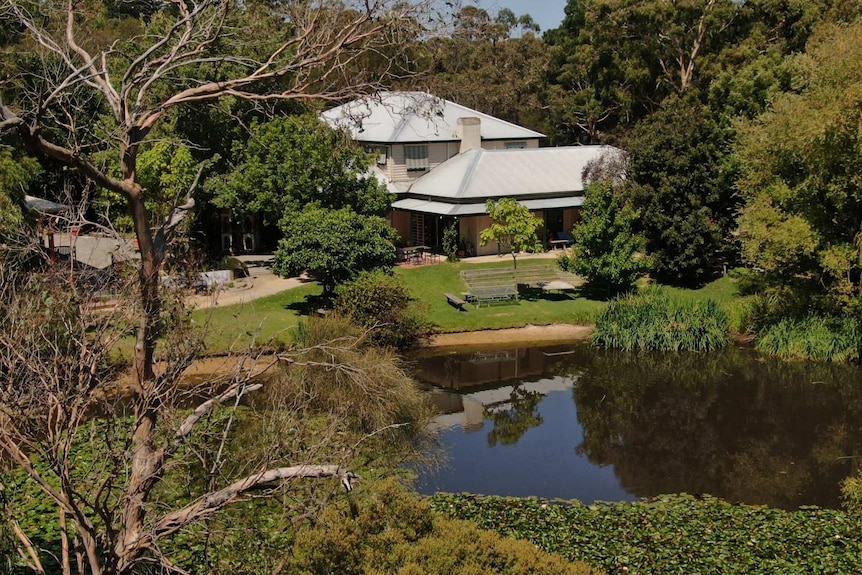 The main ashram building is shown behind a lake on the grounds.