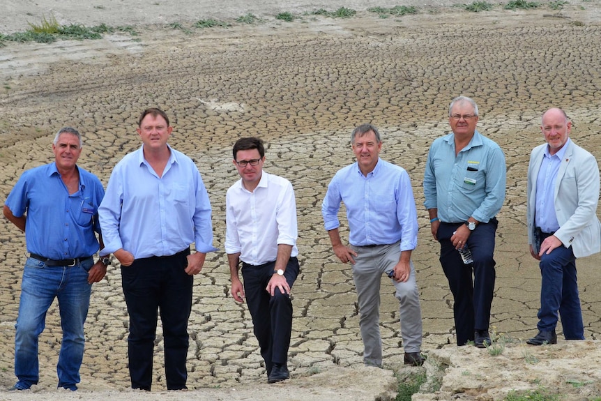 Agriculture minister David Littleproud stands at the edge of a dry dam with a cohort of Nationals candidates and members.