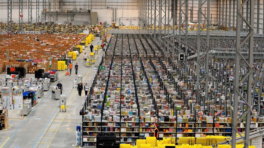 Many shelves line the floor of a huge warehouse.